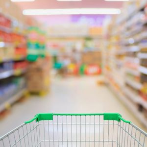 Shopping cart being pushed down a grocery store aisle